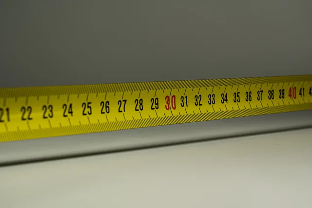 Close-up view of a yellow measuring tape with centimeter marks, emphasizing precision in measurement. Marketing analytics for Scottish and Welsh campaign attribution