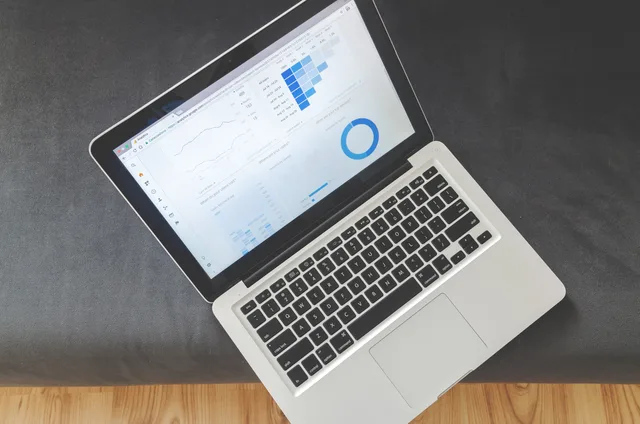 Overhead view of a laptop showing data visualizations and charts on its screen. Why no marketing attribution provider is named best: six candidates on HOLD