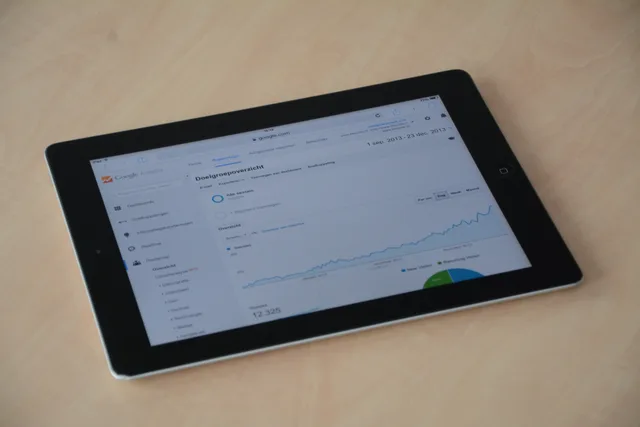 A digital tablet showing a web analytics dashboard with graphs and charts. Marketing attribution reviews: a gated test framework
